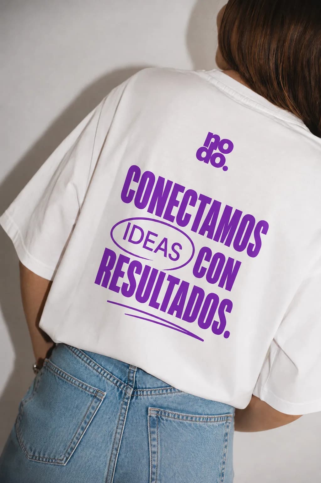 Camiseta de Nodo con el lema «Conectamos ideas con resultados» impreso en morado.
